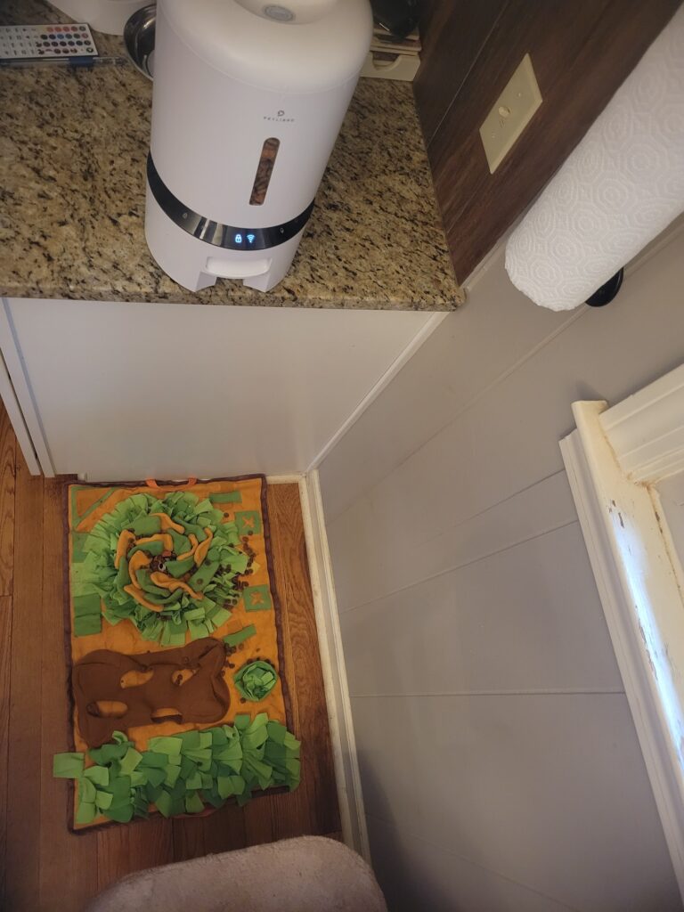 Automatic pet feeder pours onto snuffle mat.